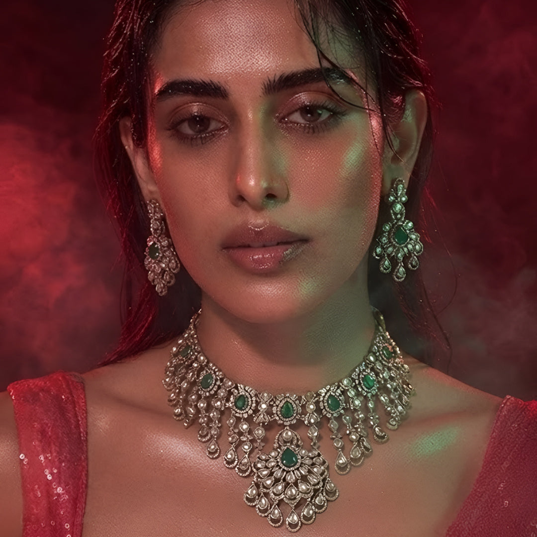 "Antique gold Kundan waterfall choker necklace with cascading fringe and emerald accents, matching chandelier drop earrings"