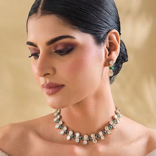 Gold-plated necklace set with green round stones, white teardrop crystal stones, and matching stud earrings for women, ideal for party, festive, and wedding wear.