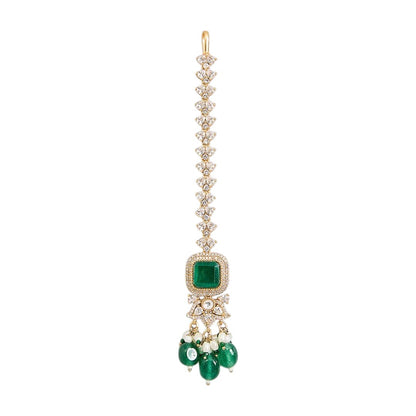 "Gold-toned maang tikka with layered polki stones, emerald green floral accents and teardrop pendant, traditional Indian bridal jewelry"