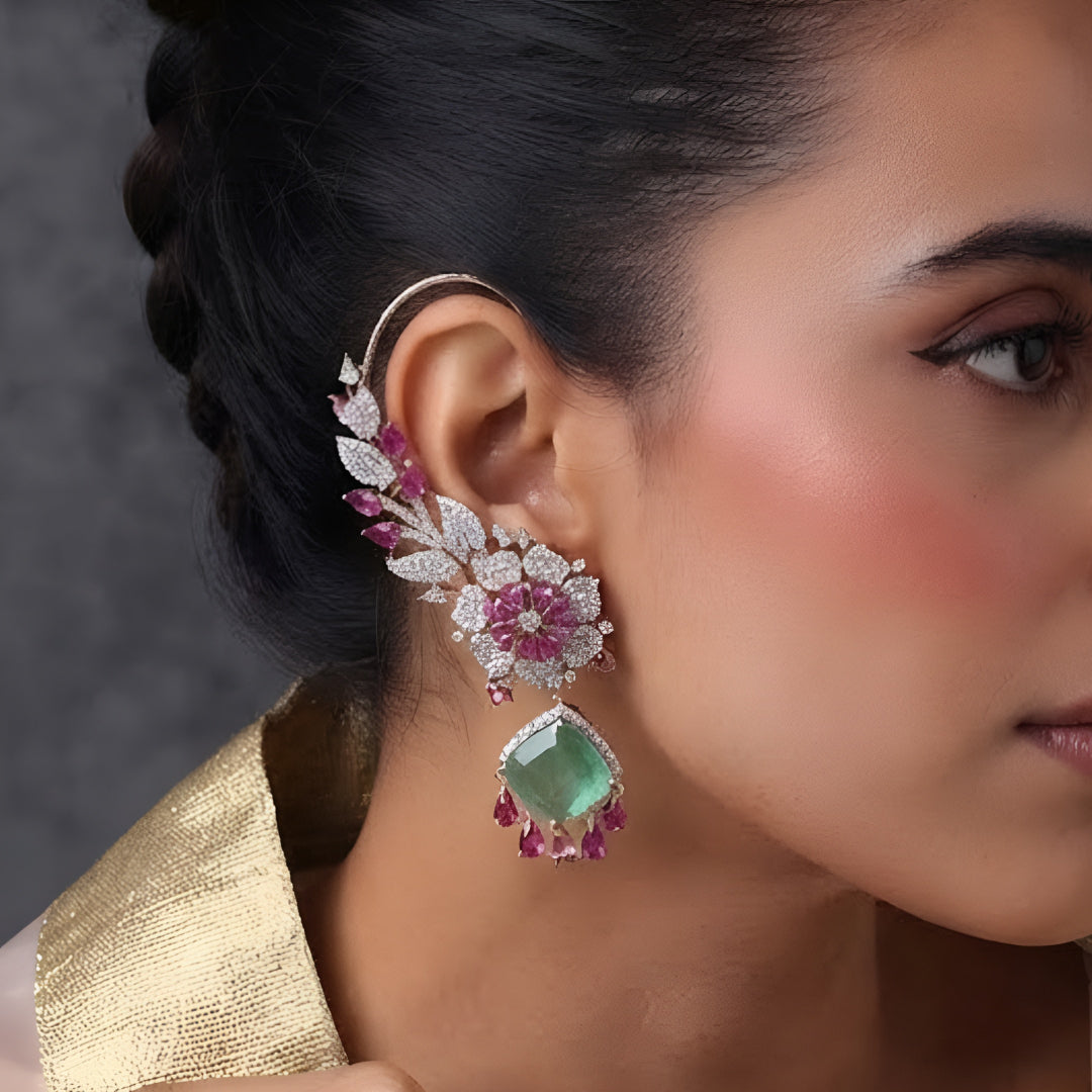 Rose gold American diamond ear cuff earrings with ruby pink pear stones and mint green cushion-cut drops, held in hand