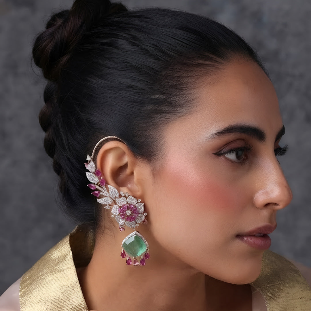 Rose gold American diamond ear cuff earrings with ruby pink pear stones and mint green cushion-cut drops, held in hand
