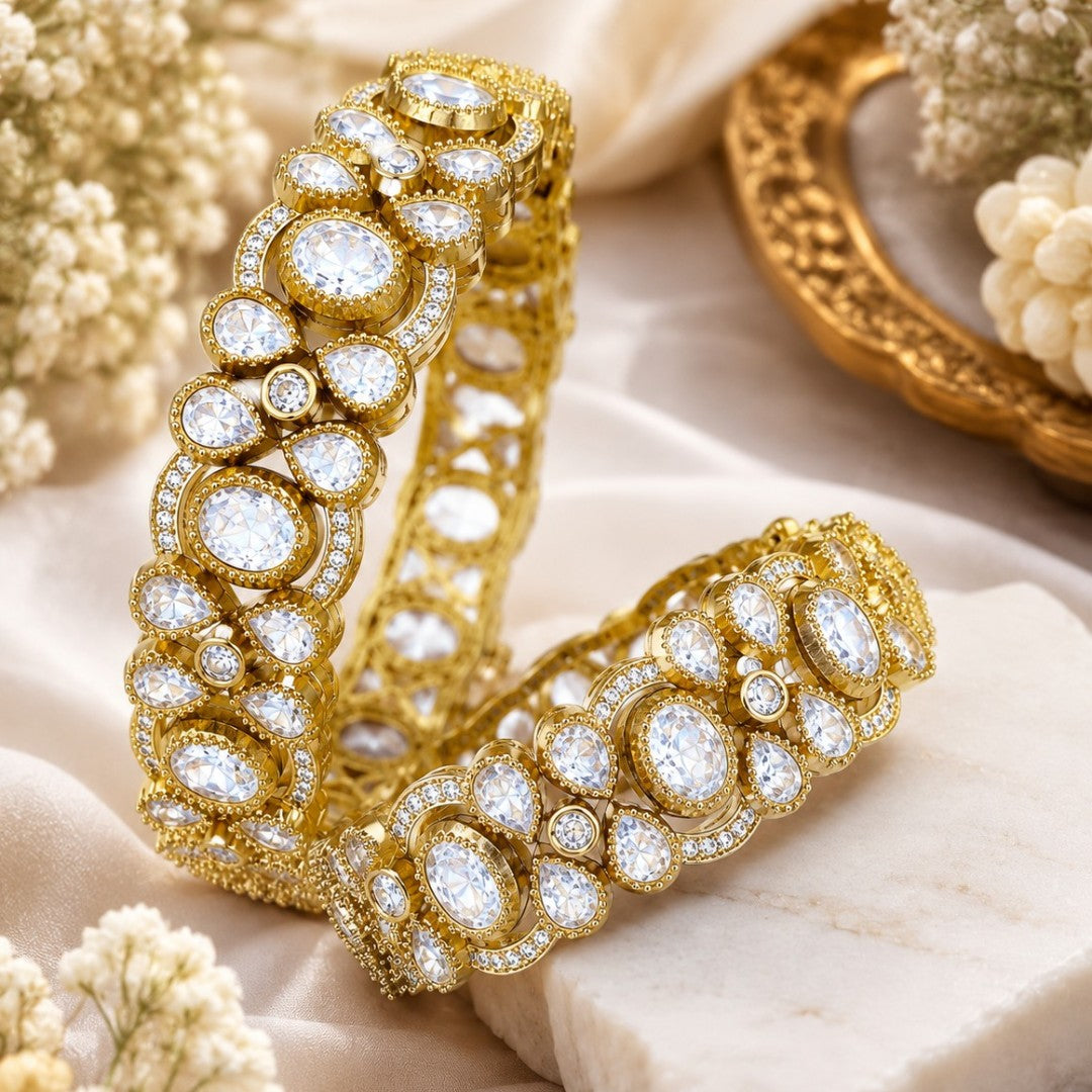 "Pair of wide gold-plated bridal bangles with bezel-set white crystals in openwork design"
