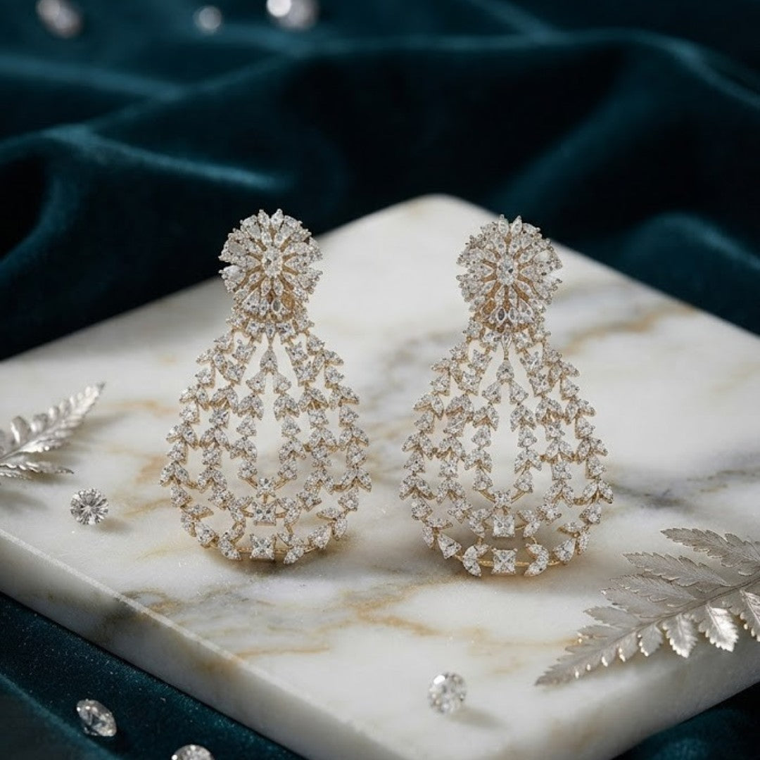 Gold-toned white stone chandelier earrings with floral top and teardrop design"