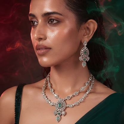 "Antique gold double-strand Kundan necklace with teardrop emerald pendant, matching drop earrings"