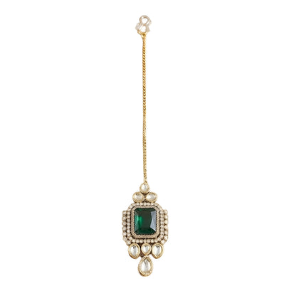 Gold maang tikka with emerald cut green stone in kundan halo setting and pearl chain, Indian bridal hair jewelry on white background
