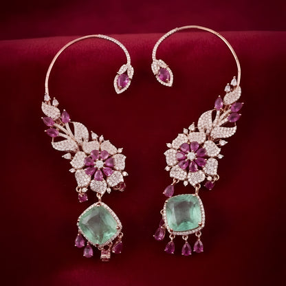 Rose gold American diamond ear cuff earrings with ruby pink pear stones and mint green cushion-cut drops, held in hand