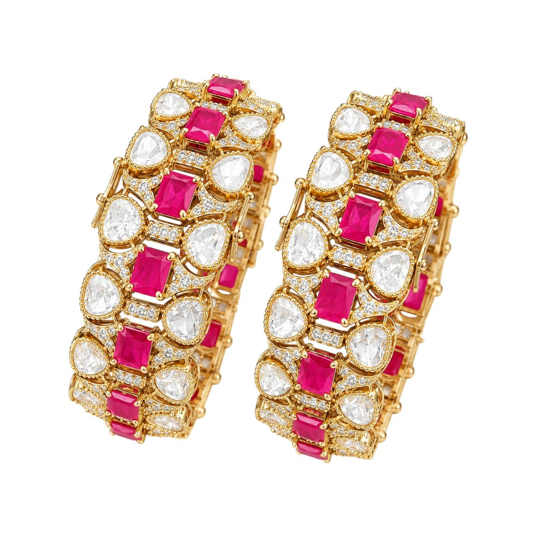 Pair of gold-finish wide kada bangles with ruby-pink emerald-cut stones, polki-style clear pear stones, and American diamond detailing