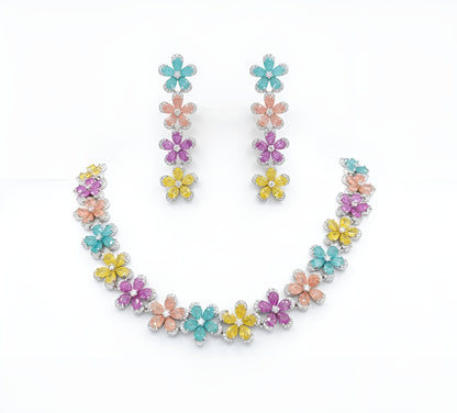 Silver plated multicolour flower American diamond necklace set with aqua, peach, pink and yellow stones and matching drop earrings on a marble slab