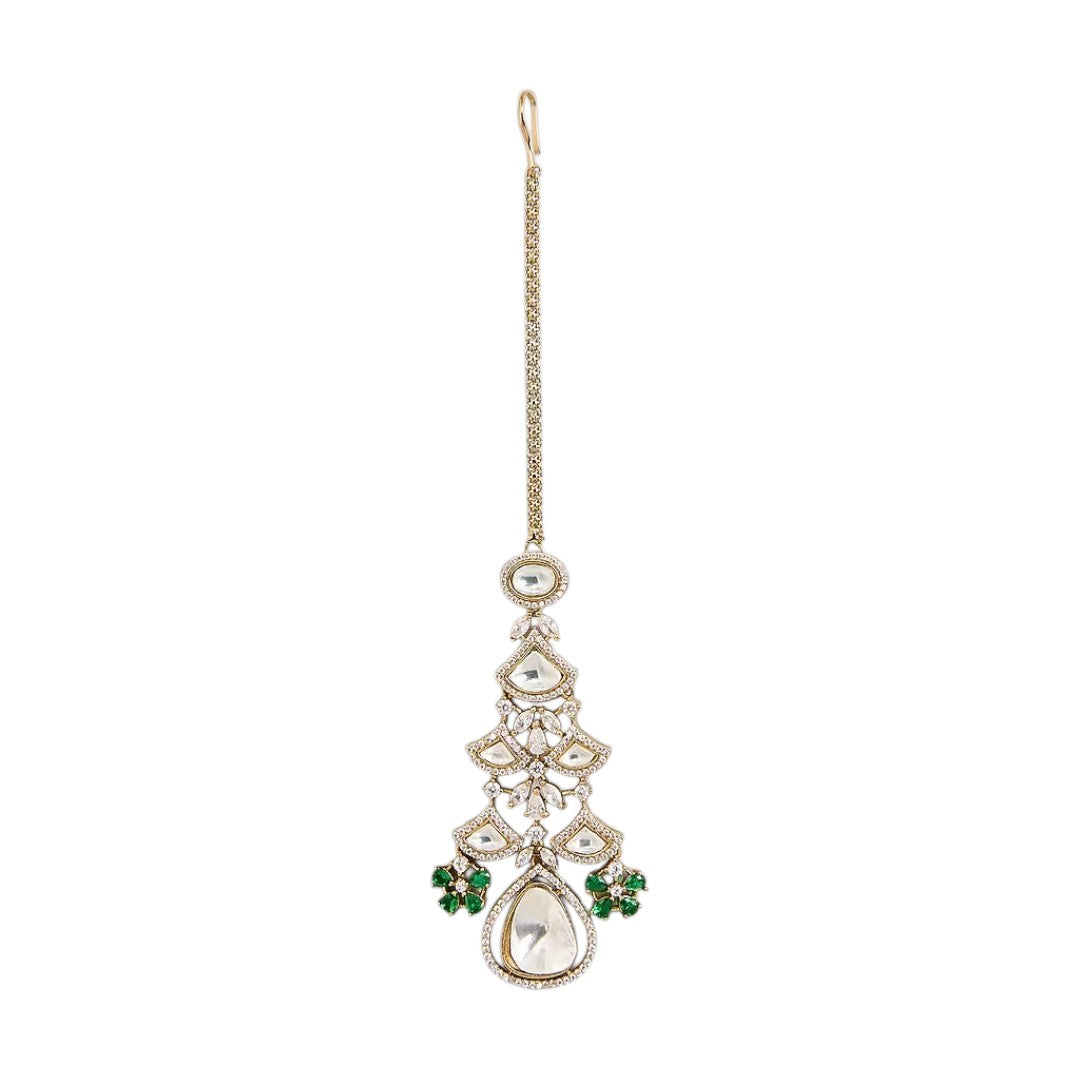 "Gold-toned maang tikka with layered polki stones, emerald green floral accents and teardrop pendant, traditional Indian bridal jewelry"