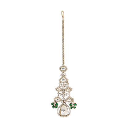"Gold-toned maang tikka with layered polki stones, emerald green floral accents and teardrop pendant, traditional Indian bridal jewelry"
