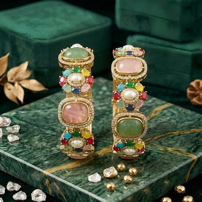 Pair of gold-finish openable kada bangles with pink and green cushion-cut stones, multicolour floral motifs, pearl-style centres, and American diamond frames