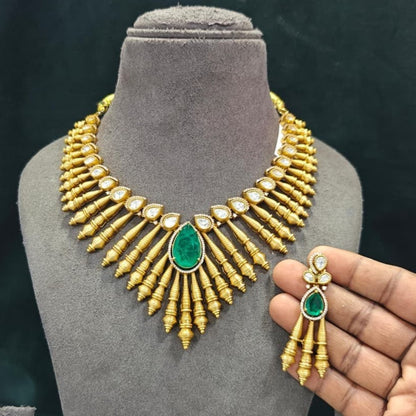 Antique matte gold necklace set with gold cone drops, polki kundan stones, emerald green pear centre stone and matching drop earrings