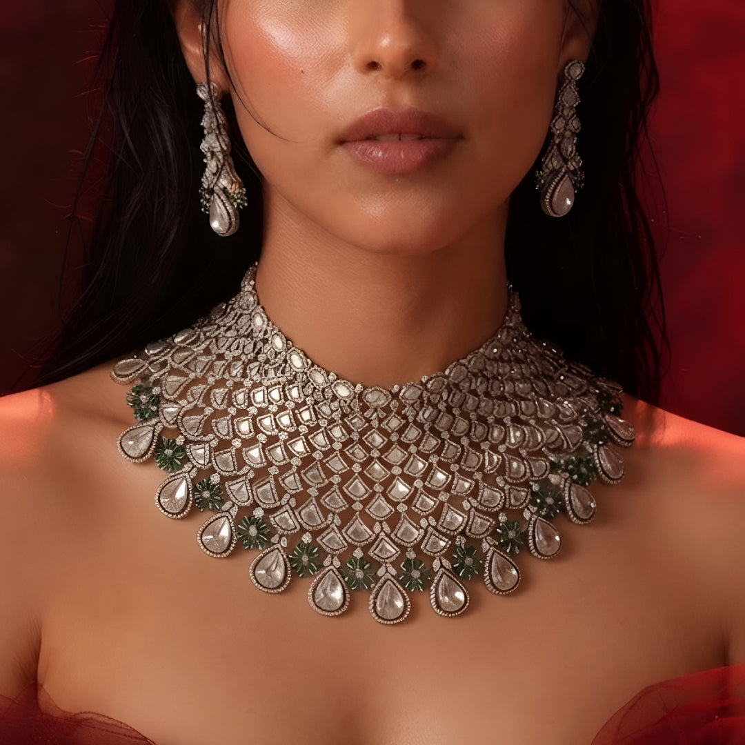 Shop this grand Kundan net-style choker with emerald floral accents & chandelier earrings. Perfect for bridal & festive occasions. Order now!