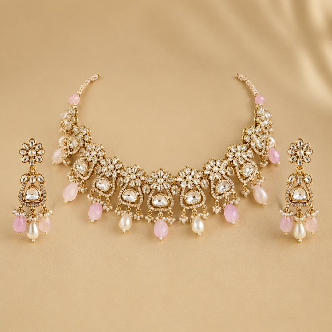Gold-plated floral Kundan choker necklace set with pink beads, pearl drops, and matching earrings for bridal, wedding, and festive wear.