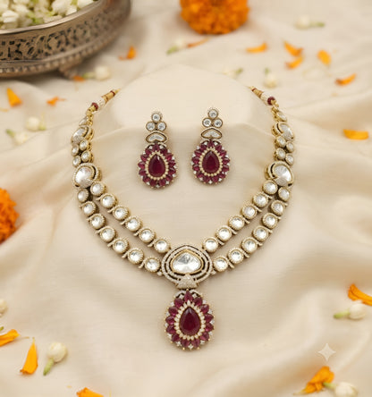 Antique gold two-strand polki kundan necklace with ruby red teardrop pendant on a display bust