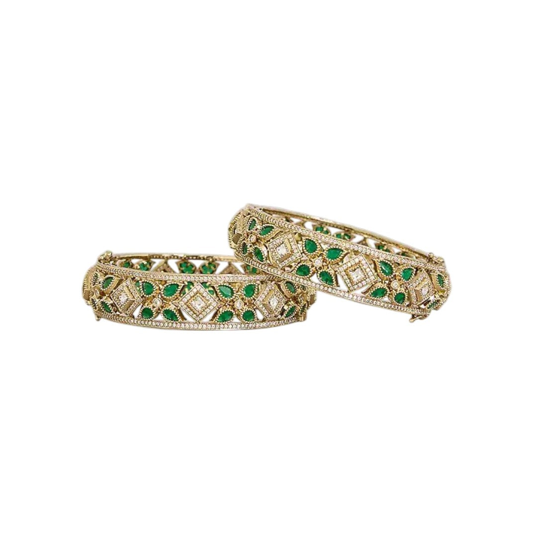 "Set of two gold-toned openwork bangles with emerald-green marquise stones and white CZ floral motifs, traditional Indian jewelry"