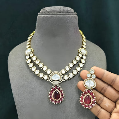 Antique gold two-strand polki kundan necklace with ruby red teardrop pendant on a display bust