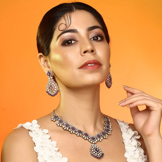 Silver plated necklace set with purple stones and matching earrings featuring intricate floral design for party and bridal wear
