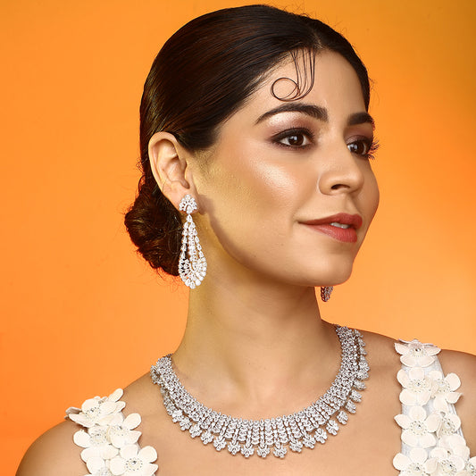 Silver American diamond necklace set with heart-shaped drop design and matching long earrings on white background