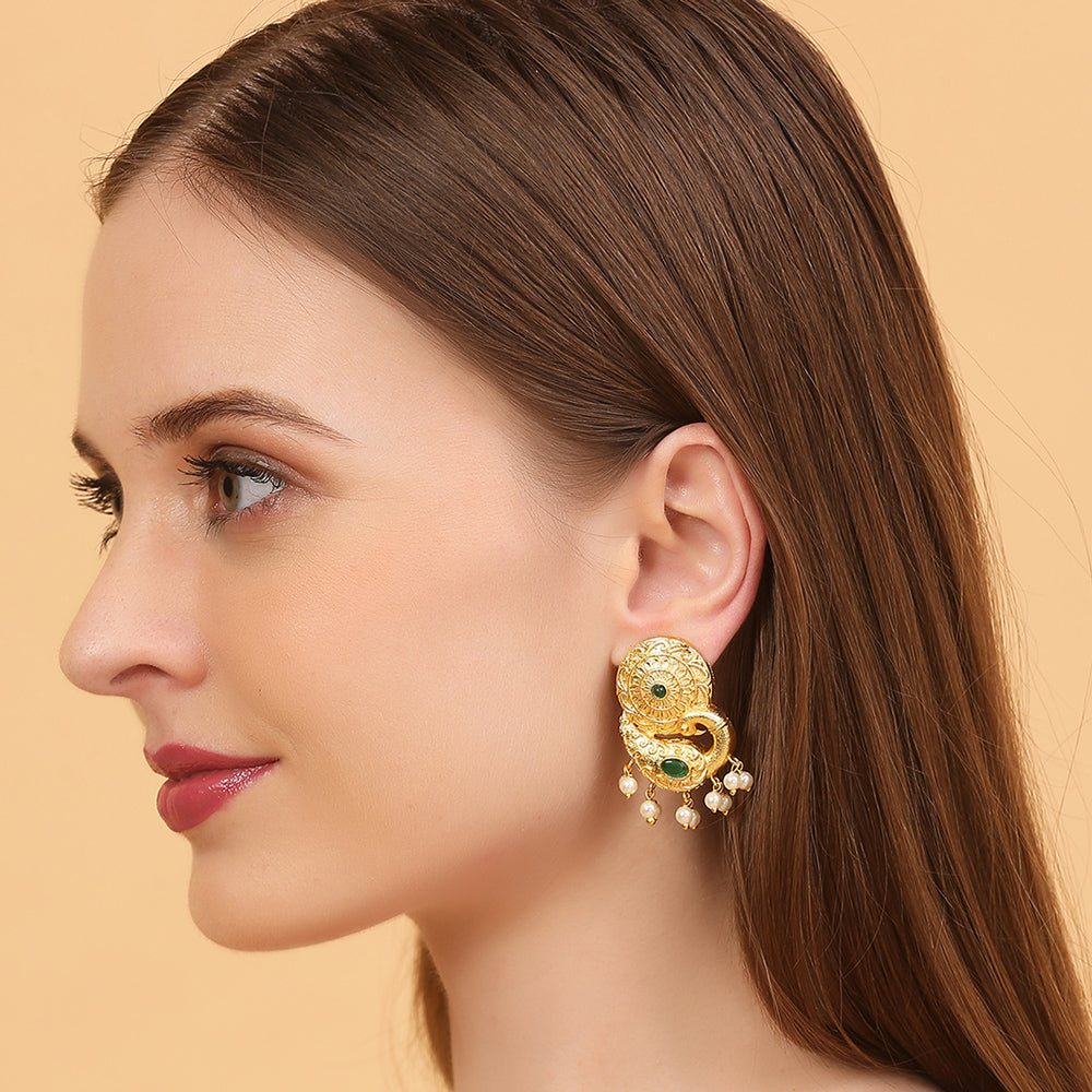 Gold peacock temple earrings with green stone accents and pearl drop detailing on neutral background