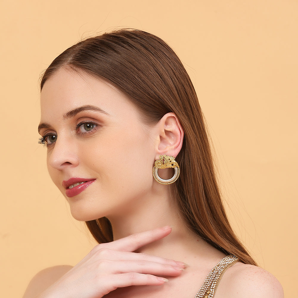 Dual tone gold and silver floral hoop earrings with intricate traditional design on neutral background