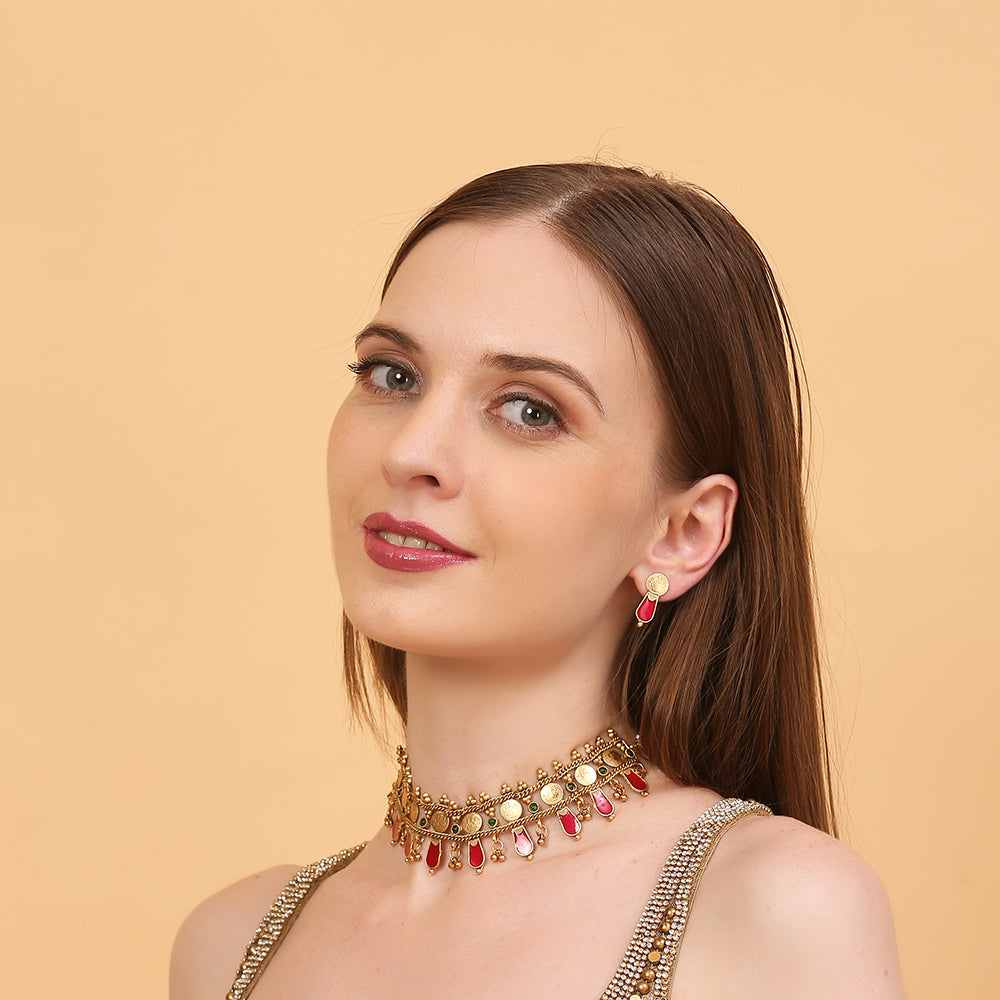Aviana gold plated temple necklace set with red drops, green stones, and matching earrings on white background
