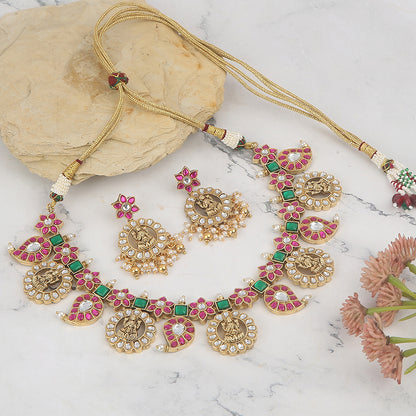 Gold plated temple Lakshmi necklace set with pink and green stones and matching earrings with pearl drops on white background