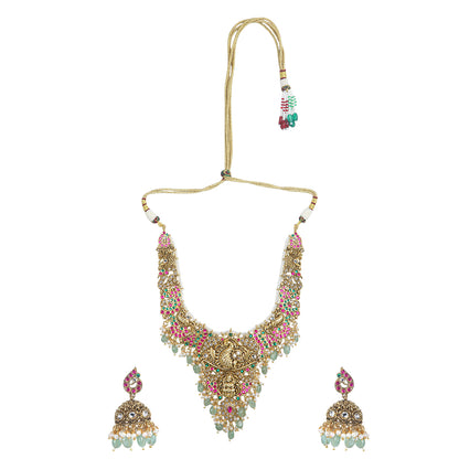 Gold plated temple Lakshmi bridal necklace set with pink green stones and jhumka earrings with pearl and bead drops on white background