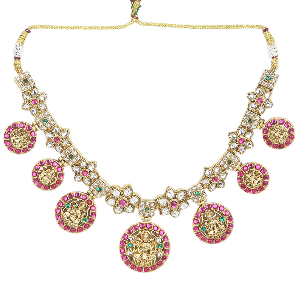 Gold plated Lakshmi coin necklace set with pink stones and matching earrings on white background
