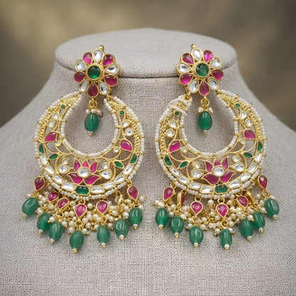 "Gold polish Kundan Meenakari chandbali earrings with pink and green stones, green bead drops and pearl fringe on mannequin display"