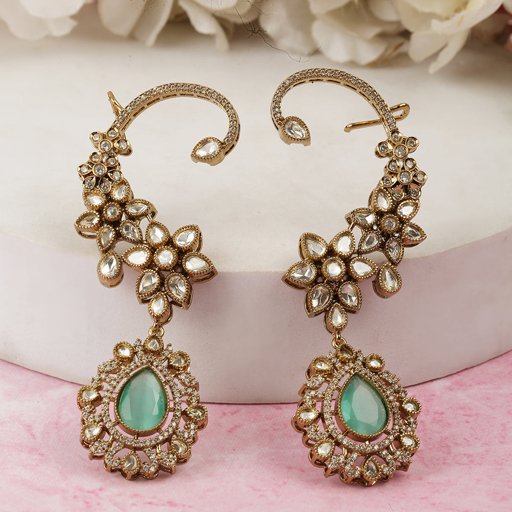 Gold floral kundan ear cuff earrings with green teardrop gemstone and intricate design