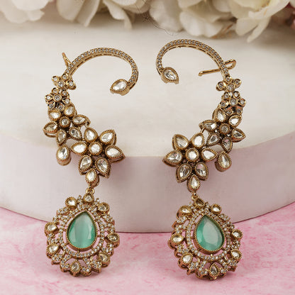 Gold floral kundan ear cuff earrings with green teardrop gemstone and intricate design
