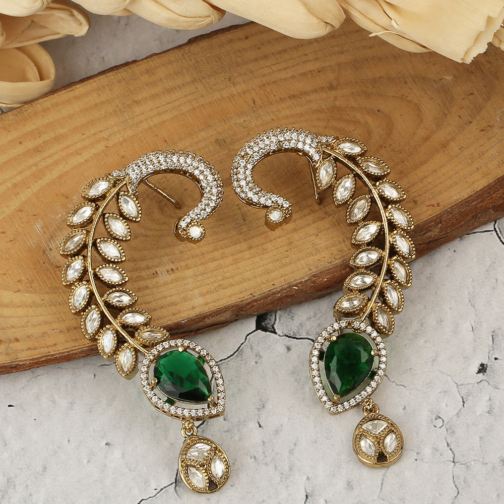 Gold plated American diamond ear cuff earrings with green teardrop stone and leaf design on white background