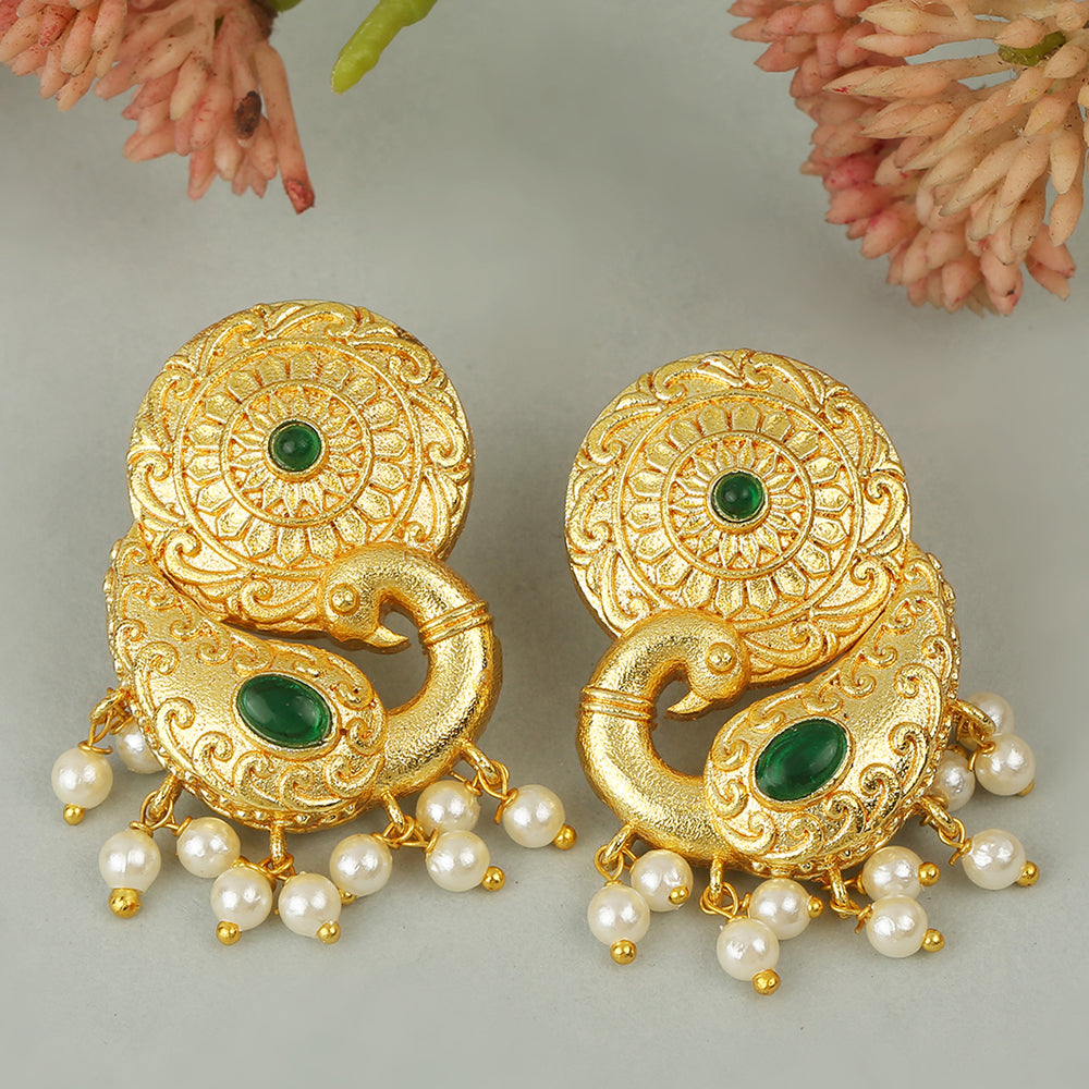 Gold peacock temple earrings with green stone accents and pearl drop detailing on neutral background