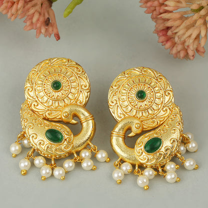 Gold peacock temple earrings with green stone accents and pearl drop detailing on neutral background