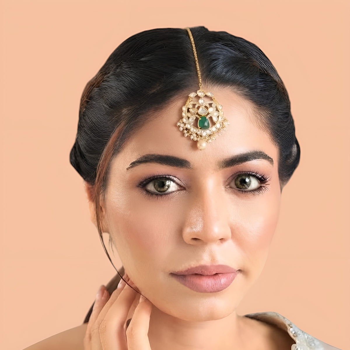 Gold-plated kundan polki style maang tikka with emerald green centre stone, clear floral medallion, pearl fringe, pearl drop and box chain with hook