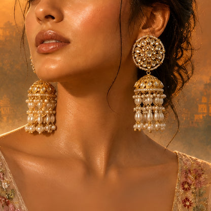 Antique gold Kundan jhumka earrings with floral stud and pearl tassel drops for women.