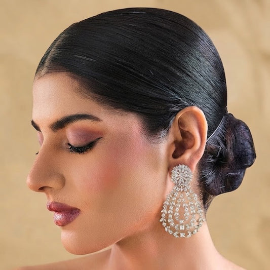 Gold-toned white stone chandelier earrings with floral top and teardrop design"