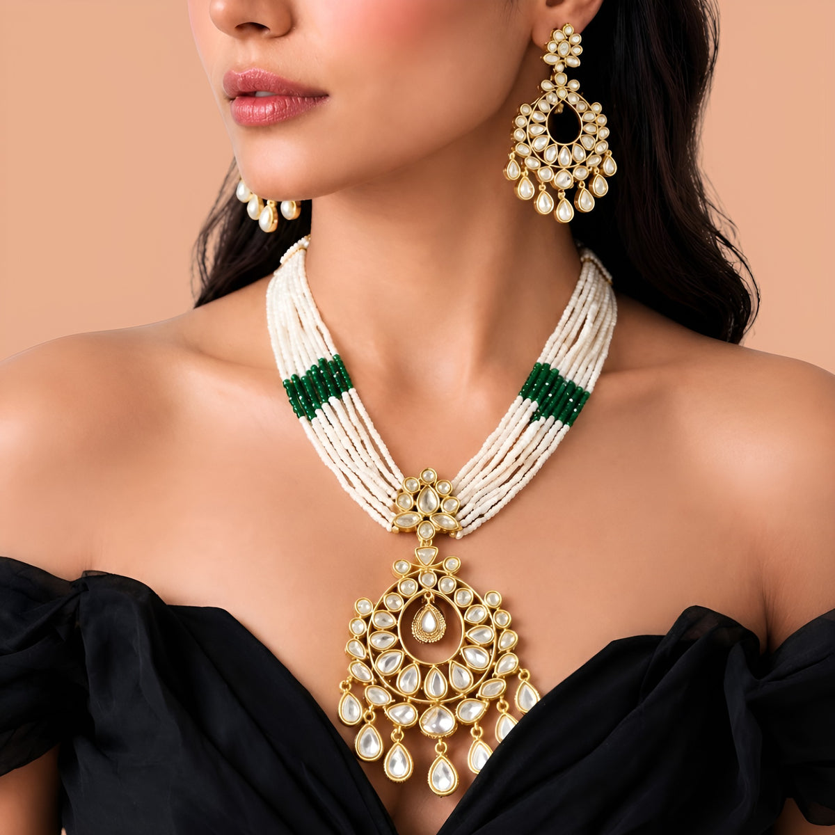 Multi-strand white pearl necklace with green bead bands and gold kundan chandbali pendant on a display bust
