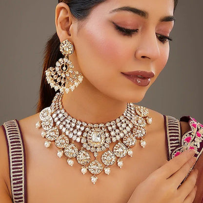 Gold-tone polki kundan choker necklace with teardrop medallions and pearl drops, shown with matching chandelier earrings