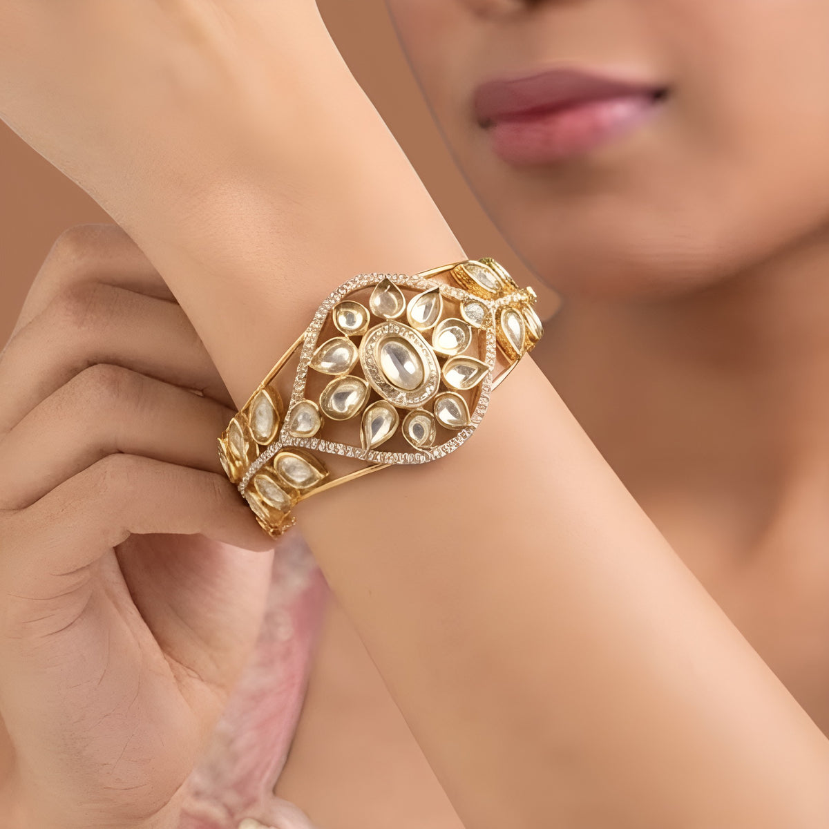 Gold finish kundan polki kada bangle with floral teardrop medallion and zircon border