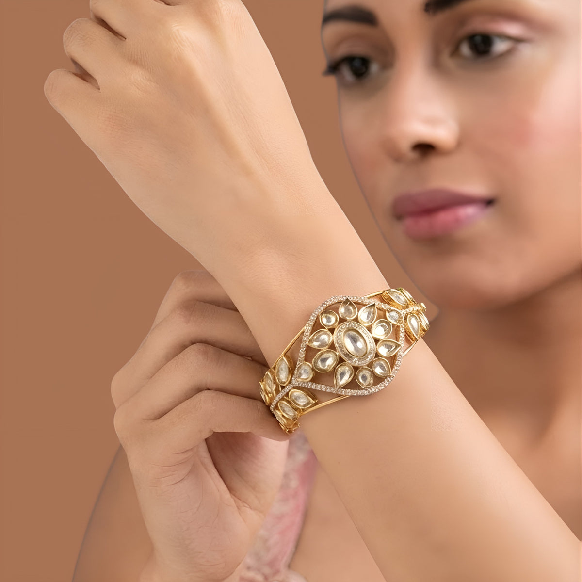 Gold finish kundan polki kada bangle with floral teardrop medallion and zircon border