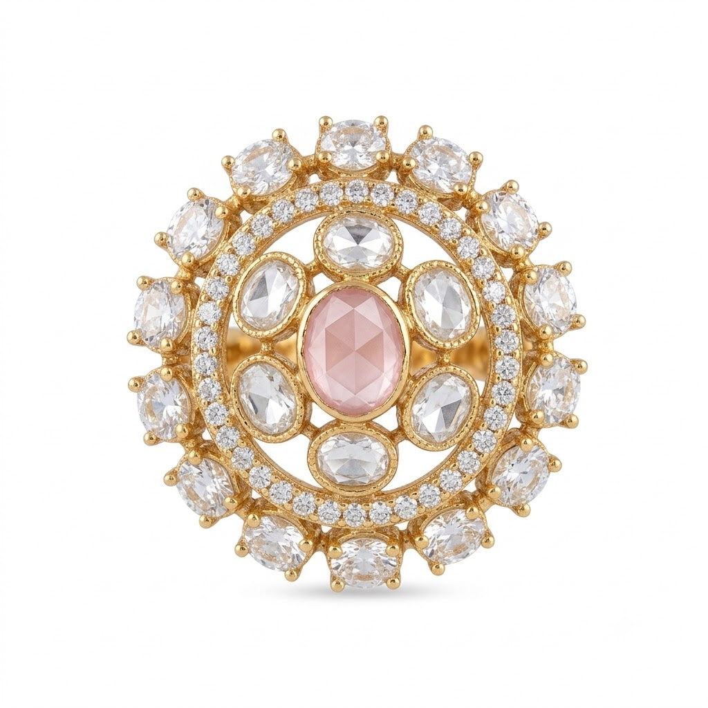 Gold-finish round cocktail ring with a blush-pink oval centre stone, clear oval stones, and American diamond halo