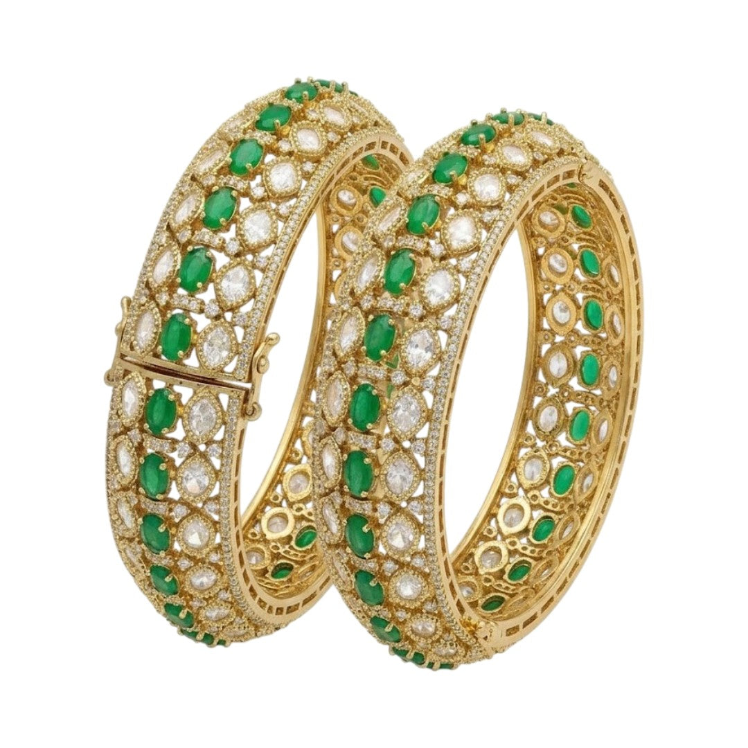 Pair of gold-finish wide kada bangles with emerald-green oval stones, polki-style clear stones, and American diamond edging