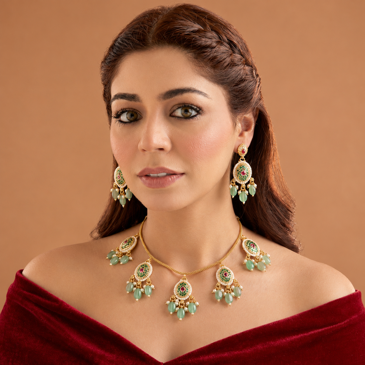 Gold plated mint green oval medallion necklace set with pink stones, green bead and pearl drops and matching earrings on a blue bust