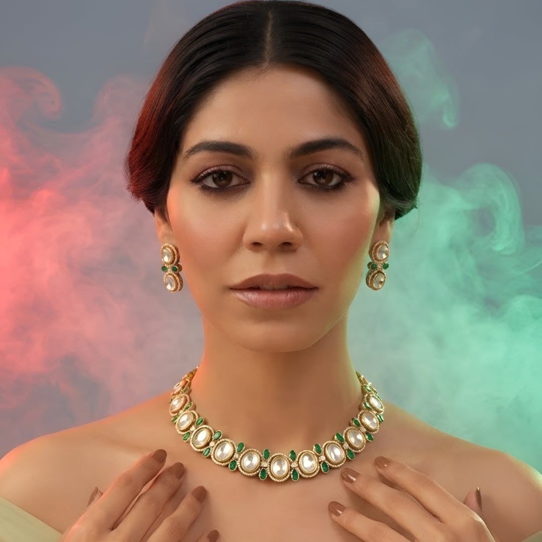 Gold-tone green kundan choker necklace set with oval kundan stones, green pear-shaped accents and matching stud drop earrings on a grey display bust