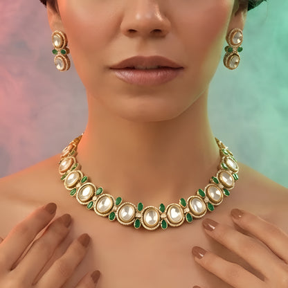 Gold-tone green kundan choker necklace set with oval kundan stones, green pear-shaped accents and matching stud drop earrings on a grey display bust