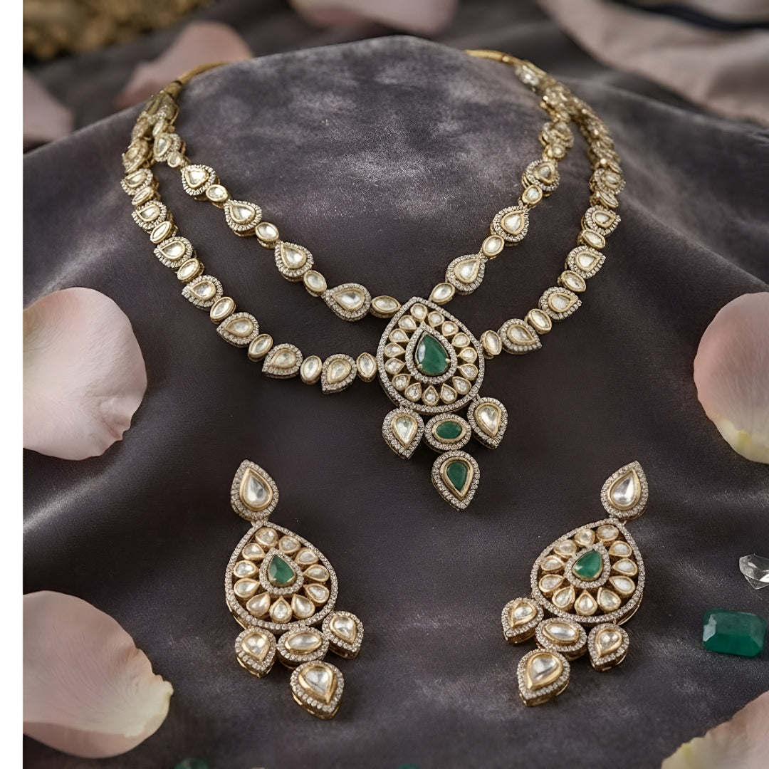 "Antique gold double-strand Kundan necklace with teardrop emerald pendant, matching drop earrings"