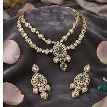 "Antique gold double-strand Kundan necklace with teardrop emerald pendant, matching drop earrings"