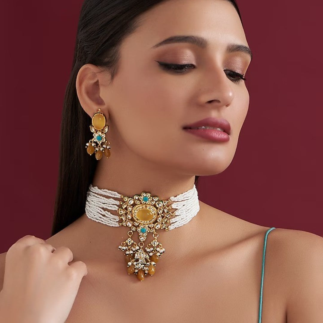 Multi-strand white beaded kundan choker necklace with yellow stone centrepiece and yellow bead drops, shown with matching earrings